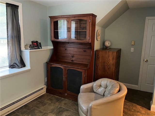 living area with a baseboard heating unit and stone finish floor