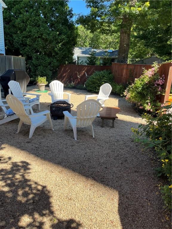 view of yard with fence and a fire pit