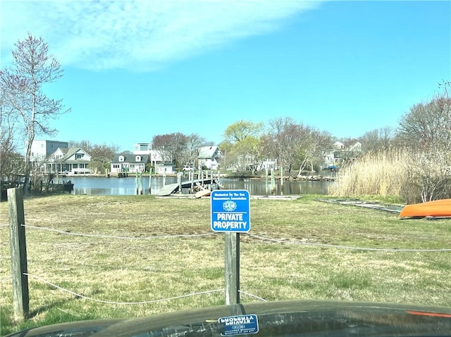 surrounding community featuring a lawn, a water view, and a residential view