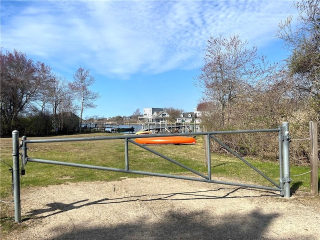 surrounding community featuring a lawn, a gate, and a water view