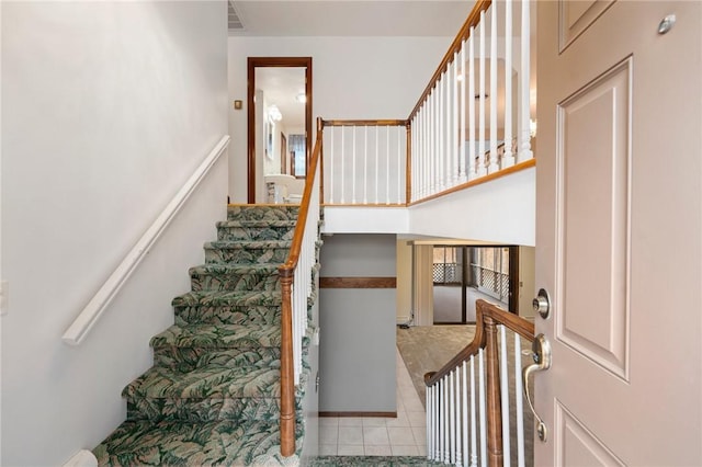 stairs featuring visible vents and tile patterned flooring