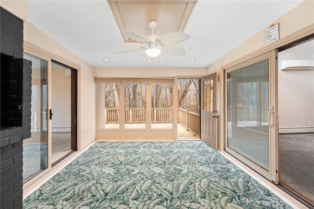 unfurnished sunroom with a wall mounted air conditioner, carpet, a baseboard heating unit, and a ceiling fan