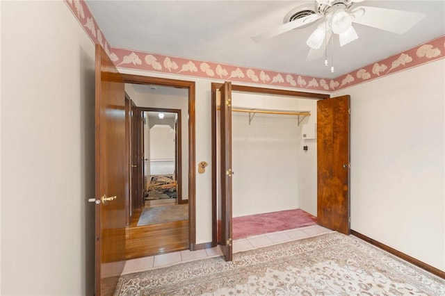 unfurnished bedroom featuring a closet, a ceiling fan, and light tile patterned floors