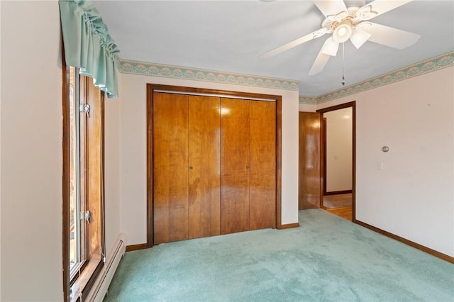 unfurnished bedroom with a closet, a baseboard heating unit, baseboards, carpet floors, and ceiling fan