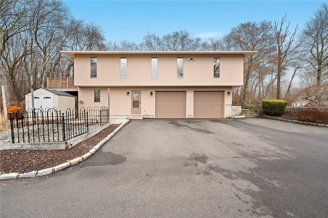 view of front of home featuring a garage, driveway, and fence