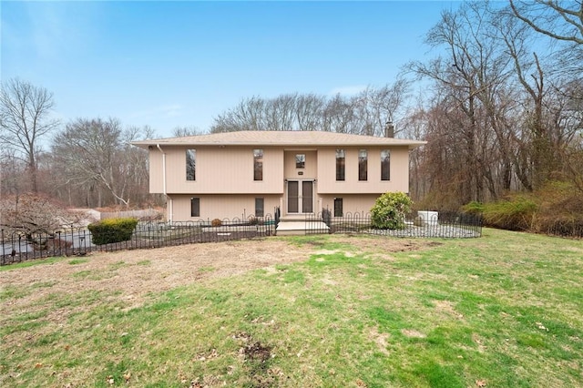 bi-level home with a front yard and fence