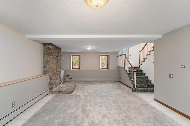 below grade area with stairway, baseboard heating, baseboards, and light colored carpet