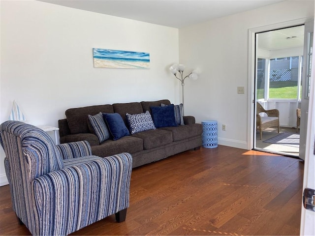 living room featuring baseboards and dark wood-style flooring