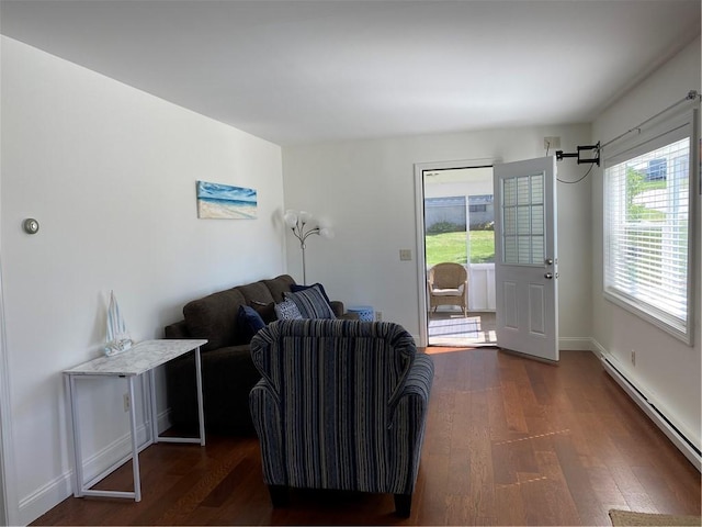 living room with dark wood-type flooring, baseboards, and baseboard heating