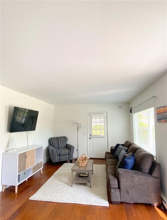 living area with wood finished floors and a healthy amount of sunlight