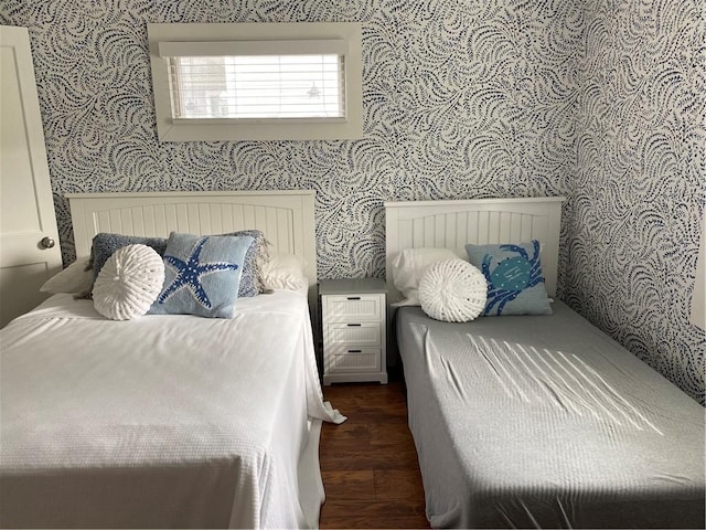 bedroom with wallpapered walls and wood finished floors