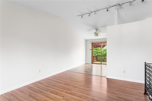 spare room featuring ceiling fan, vaulted ceiling, track lighting, and wood finished floors