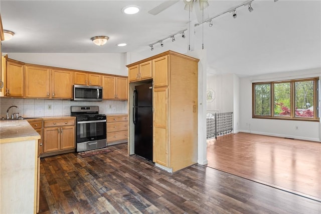 kitchen with tasteful backsplash, vaulted ceiling, rail lighting, light countertops, and stainless steel appliances