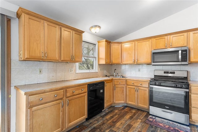 kitchen featuring light countertops, stainless steel appliances, vaulted ceiling, and a sink