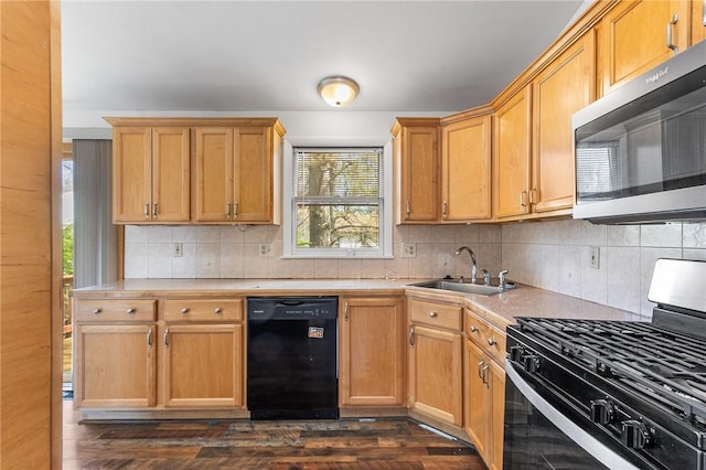 kitchen featuring dark wood-style flooring, light countertops, a sink, appliances with stainless steel finishes, and backsplash