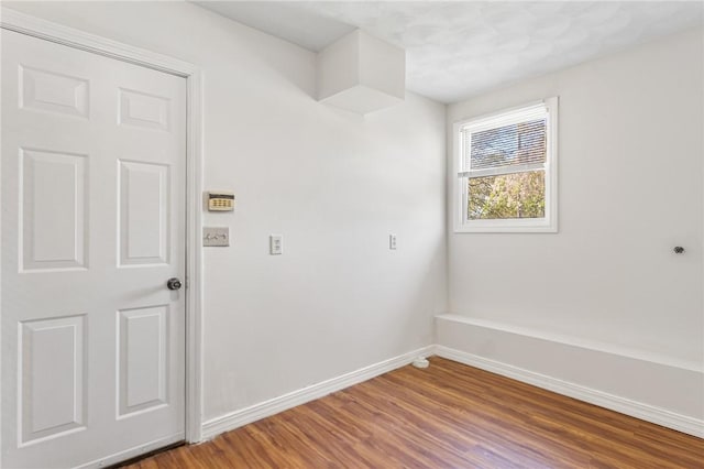 unfurnished room with baseboards and wood finished floors