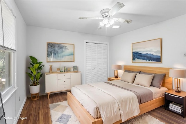 bedroom with baseboards, ceiling fan, wood finished floors, and a closet