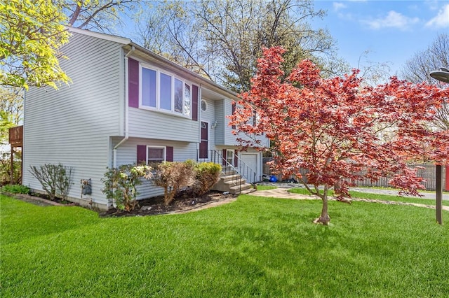 raised ranch featuring a front yard and a garage