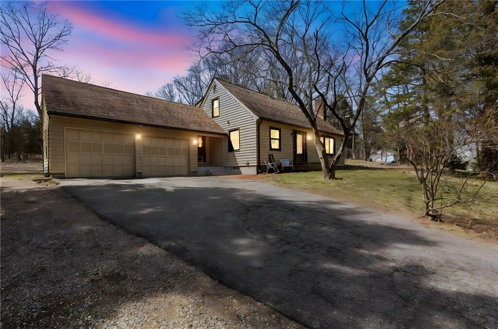 view of front of property featuring driveway, a garage, and a lawn