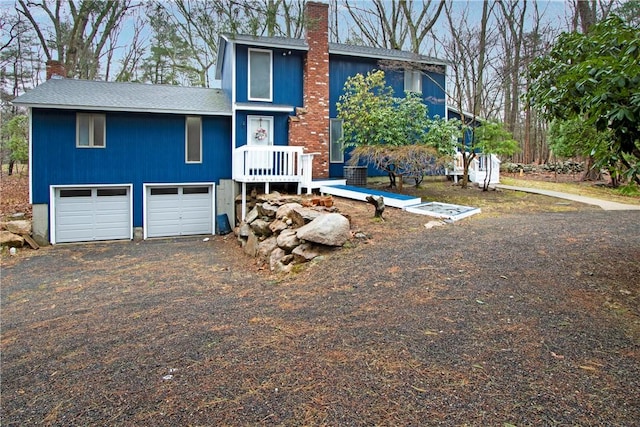 20 Holly Hill Ct, East Greenwich, RI 02818 - view of front facade featuring driveway, a chimney, and a garage
