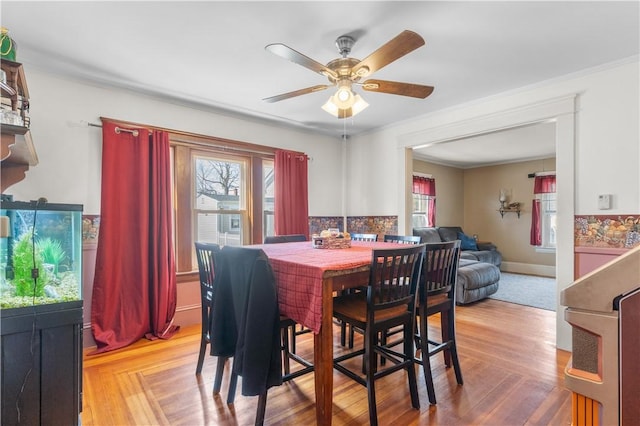 dining area with wood finished floors, ceiling fan, plenty of natural light, and crown molding