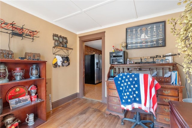 dining room with wood finished floors, crown molding, and baseboards