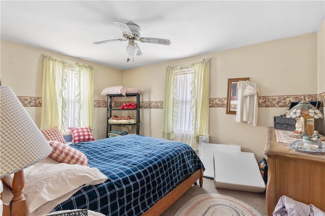 bedroom featuring a ceiling fan, multiple windows, and carpet
