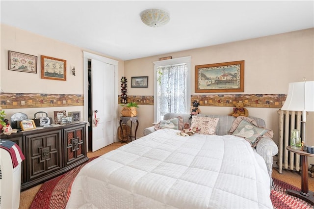 carpeted bedroom featuring radiator