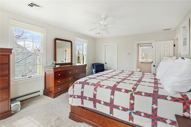 bedroom featuring baseboard heating, multiple windows, and visible vents