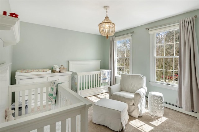 bedroom featuring a chandelier, carpet floors, and a crib
