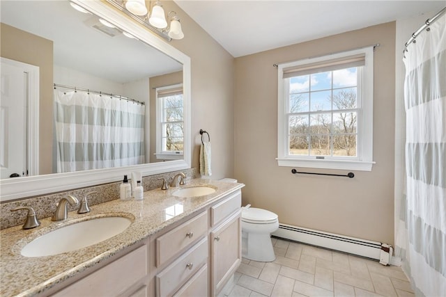 full bathroom featuring double vanity, a baseboard radiator, a sink, and toilet