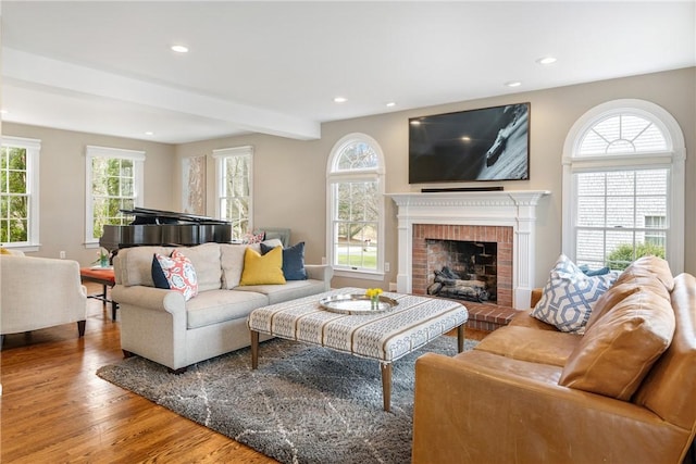 living room with baseboards, a fireplace, beam ceiling, recessed lighting, and wood finished floors