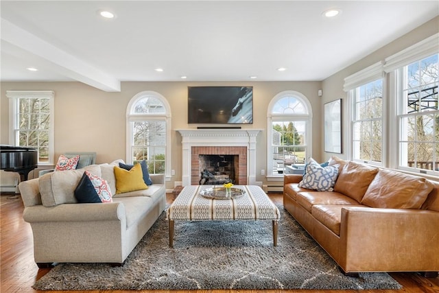 living area with a wealth of natural light, recessed lighting, and wood finished floors