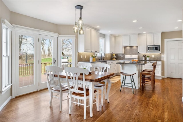 dining space featuring light wood-style flooring and recessed lighting