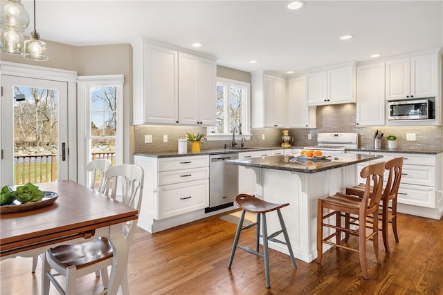 kitchen with white cabinets, a breakfast bar, a sink, and appliances with stainless steel finishes