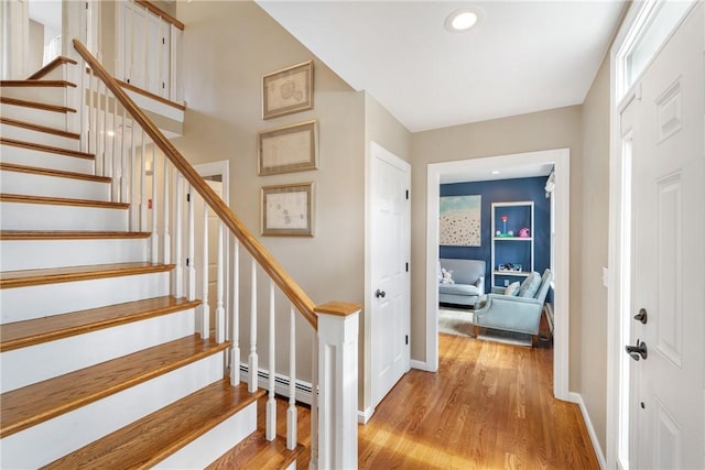 interior space with baseboards, recessed lighting, a baseboard heating unit, and wood finished floors