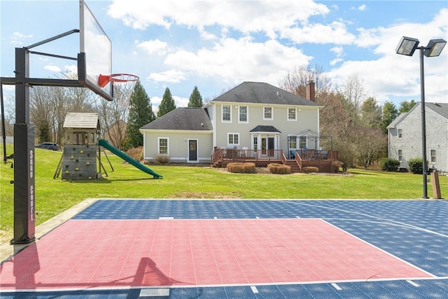 view of basketball court with a playground, a lawn, and basketball court