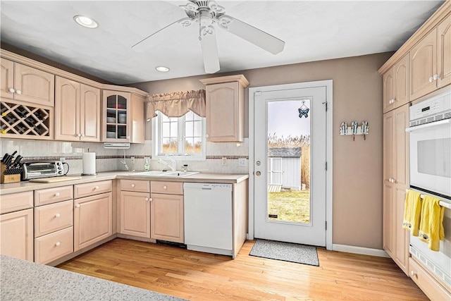 kitchen with dishwasher, light brown cabinets, and a sink