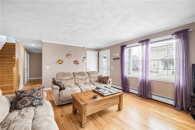 living area featuring light wood finished floors, baseboards, ornamental molding, and stairway