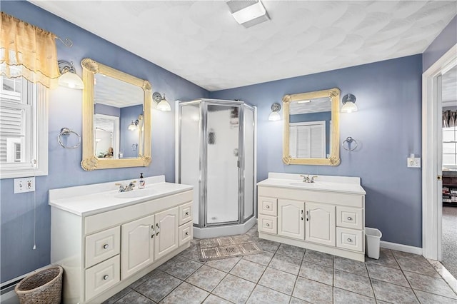 full bathroom featuring two vanities, a sink, and a stall shower