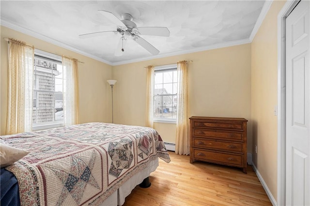 bedroom featuring light wood finished floors, crown molding, and multiple windows