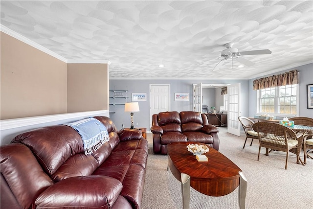 living room with light carpet, baseboards, ceiling fan, and crown molding