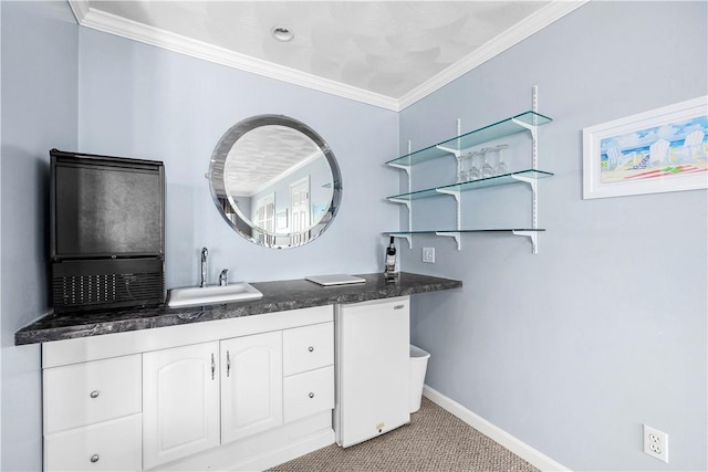 bathroom featuring baseboards, crown molding, and vanity