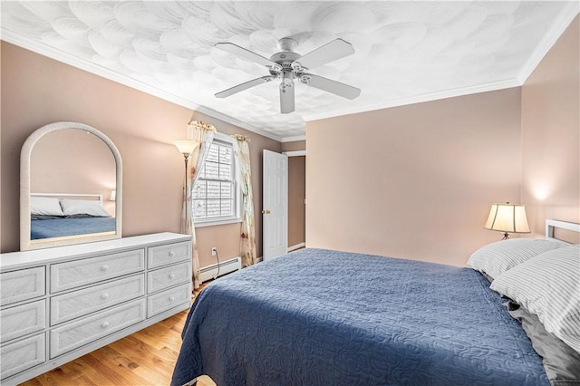 bedroom with light wood finished floors, baseboard heating, ornamental molding, and a ceiling fan