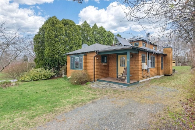 chalet / cabin featuring a chimney and a front yard