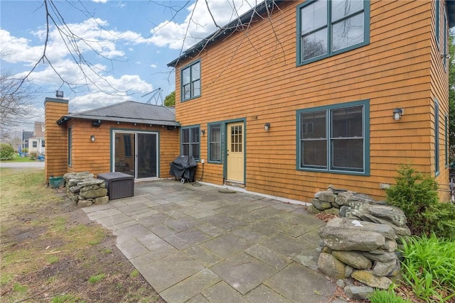 back of house featuring a chimney and a patio
