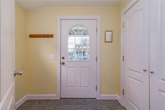 doorway to outside with vaulted ceiling and baseboards