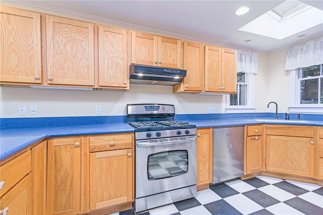 kitchen with a sink, a skylight, light floors, under cabinet range hood, and appliances with stainless steel finishes