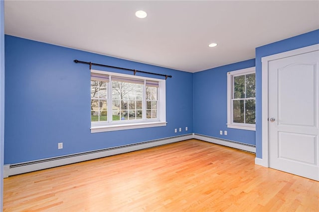 unfurnished bedroom with a baseboard heating unit, wood finished floors, baseboards, and recessed lighting