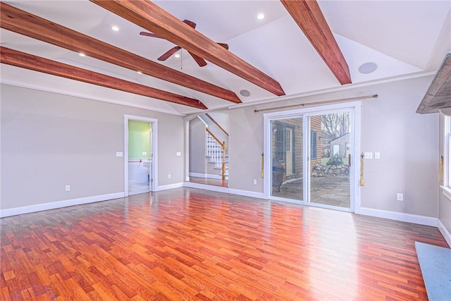 unfurnished living room featuring stairway, a ceiling fan, wood finished floors, lofted ceiling with beams, and baseboards